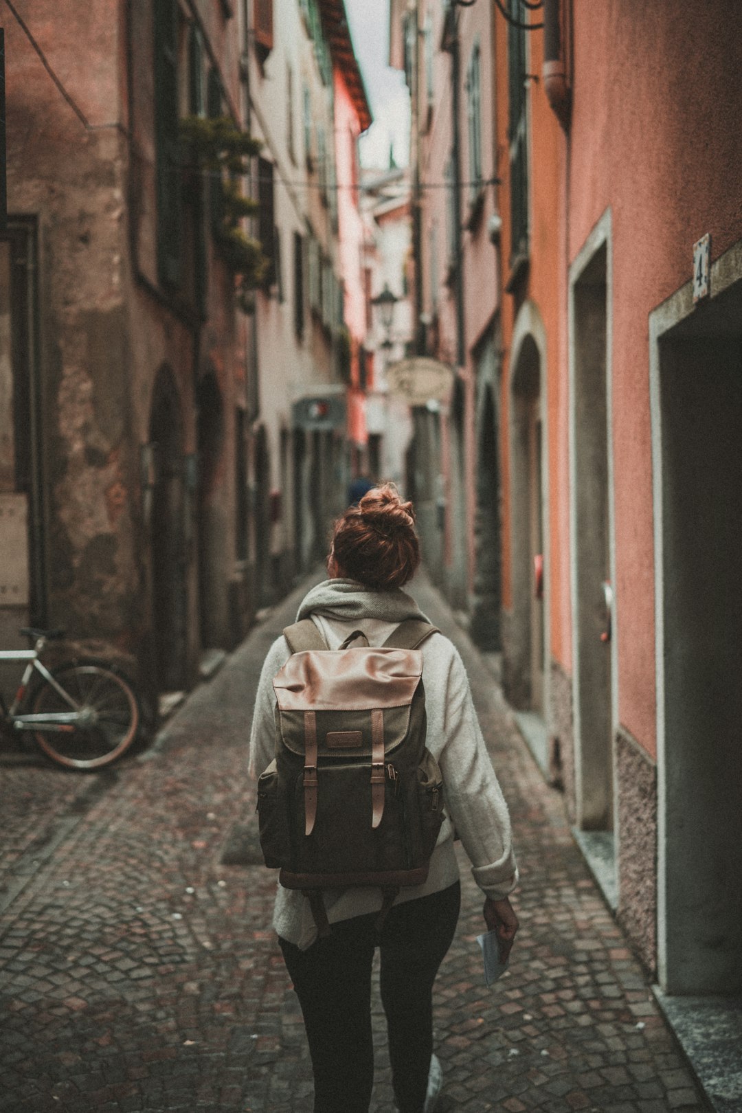 woman-walking-on-street-surrounded-by-buildings-iubgeneyvy8